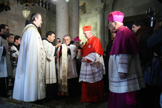 Gerusalemme, 7 gennaio 2008. Il cardinal Foley accolto dal Custode di Terra Santa, nei pressi della Pietra dell'Unzione, nella basilica del Santo Sepolcro.
