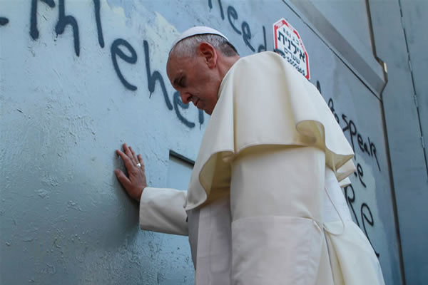 Papa Francesco sosta silenzioso al Muro di separazione israeliano che cinge Betlemme. (foto: Nour Shamaly/Pool/Flash90)[1/2]