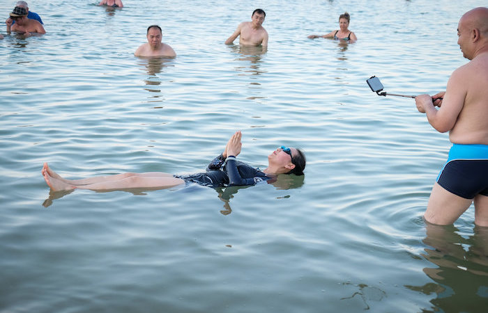 Una posa ironica per questi turisti orientali immersi nelle acque del grande bacino salato. (foto Gershon Elinson/Flash90)