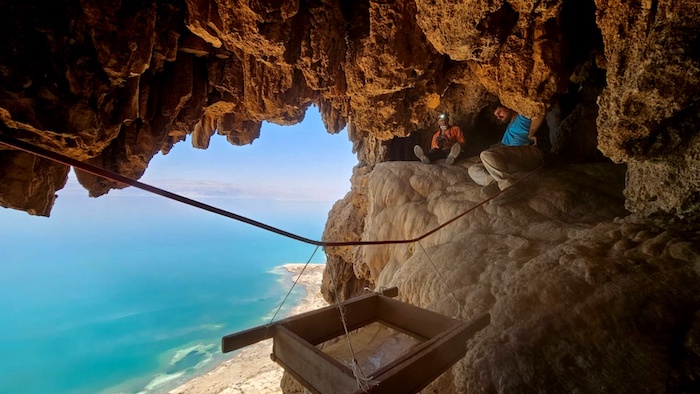 Il personale dell'Autorità israeliana per le antichità al lavoro nella grotta a picco sul Mar Morto. (foto Oriya Amichai / Israel Antiquities Authority)